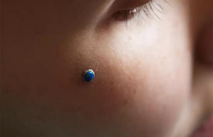 Woman with microdermal jewelry on her cheek