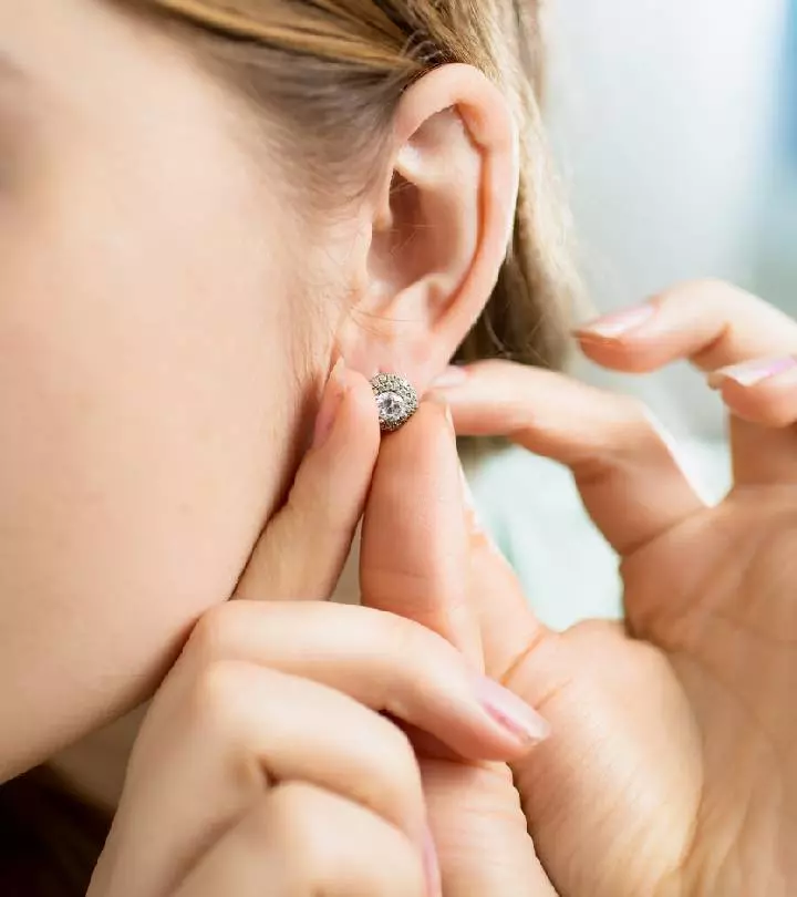 A woman changing her ear piercing jewelry