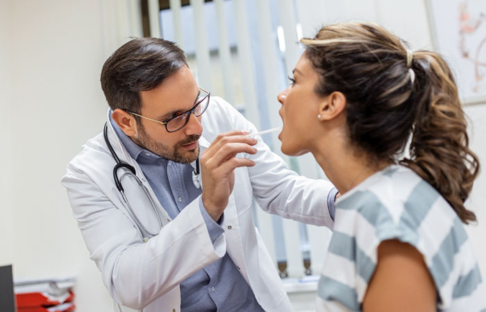 Doctor checking tongue piercing of a woman