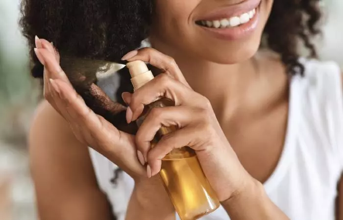 Woman Applying Oil Spray On Her Hair