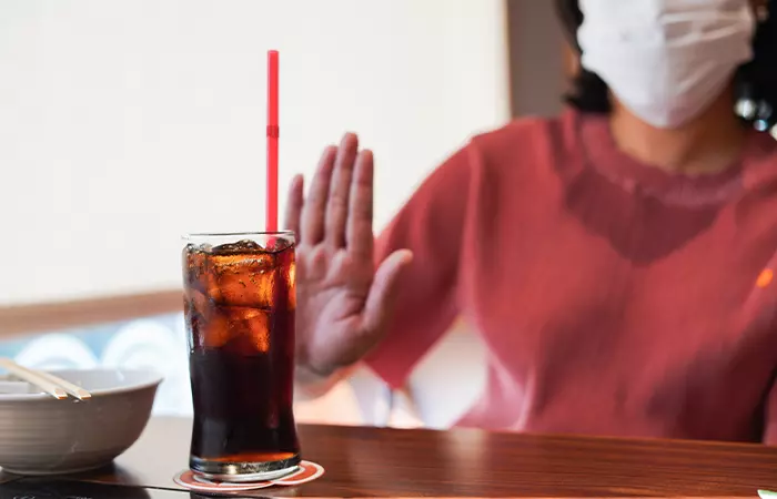 Woman avoiding drinking from a straw