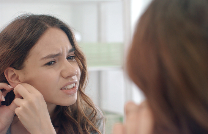 Woman with a piercing bump on her ear piercing