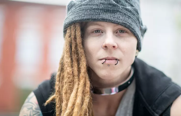Woman with snake bite lip piercing and hoop jewelry