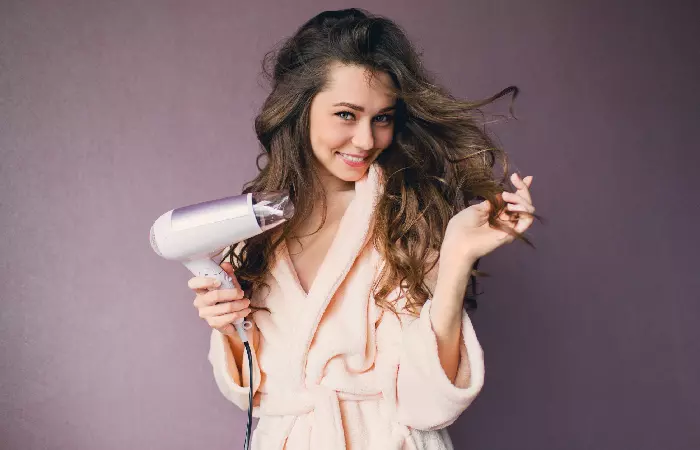 A woman blow drying her hair