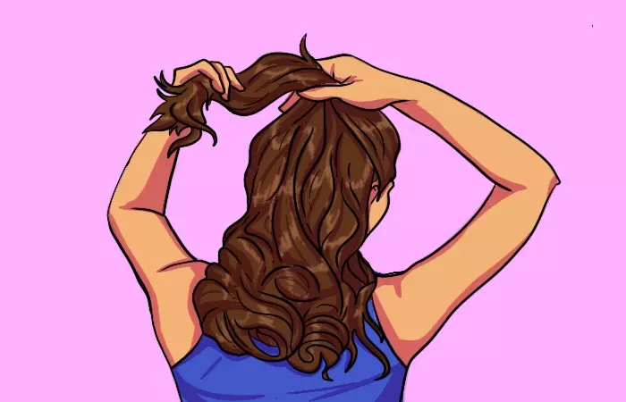 A woman dividing her hair before getting victory rolls