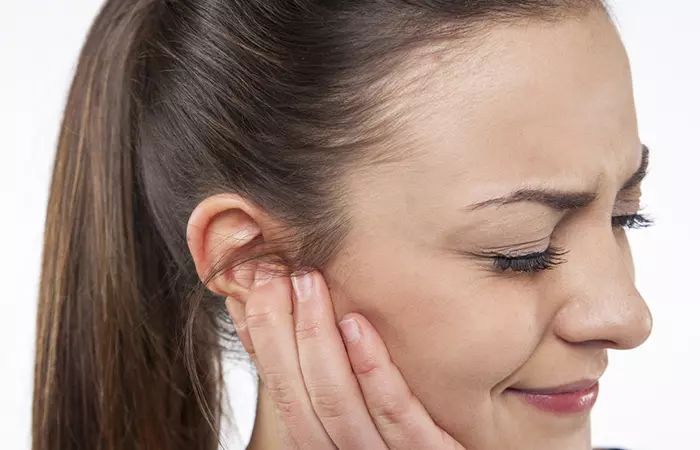 A woman in pain due to her industrial piercing infection 