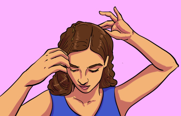 A woman parting her hair for victory rolls