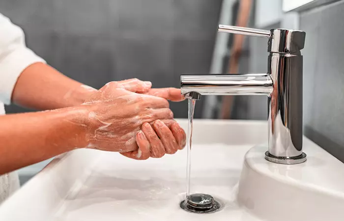 A woman washing her hands before touching her new piercing