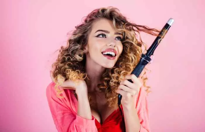 A woman with curly holding a curling iron