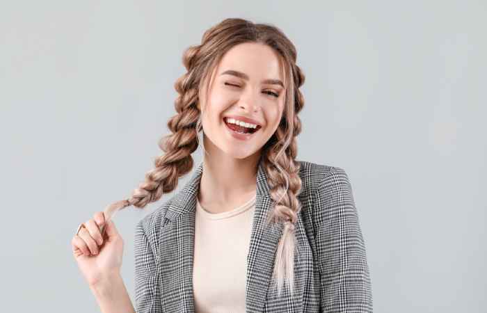 A young woman holding her braided hair