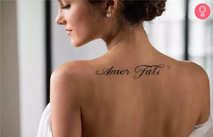A woman with an amor fati tattoo on the upper back