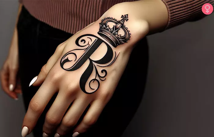 Beautiful R tattoo with a crown on the hand