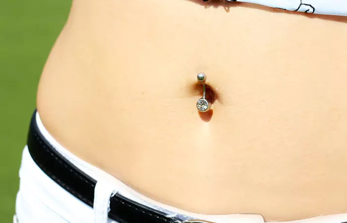 A close up of a woman with a belly button piercing