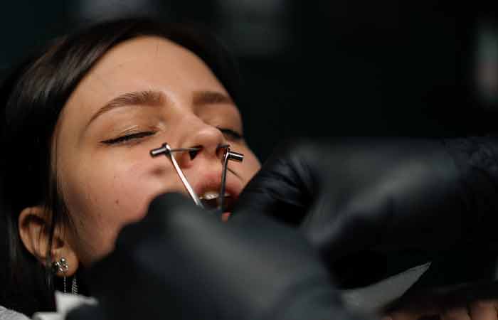 Woman getting a septum piercing done