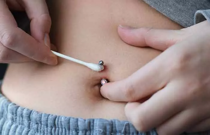 A girl cleaning her belly button piercing