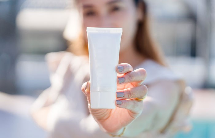 Woman holding numbing cream