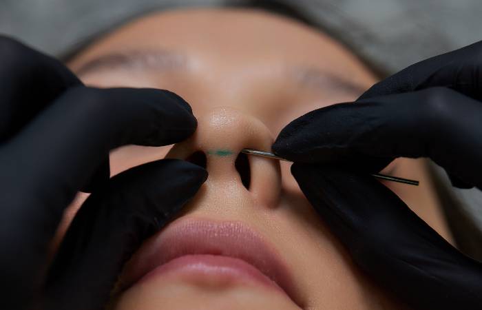 Nose piercing being done by a professional