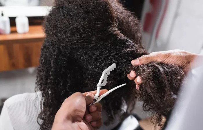 Hairstylist separating the hair into sections to create Bantu knots