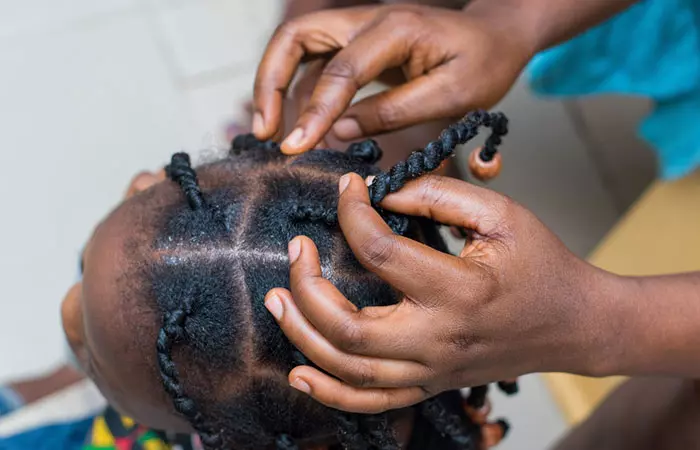 A woman twisting her daughter’s hair