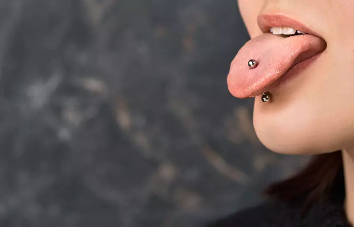 A woman sporting a barbell tongue piercing