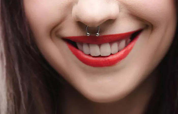 Smiling woman with a completely healed nose piercing