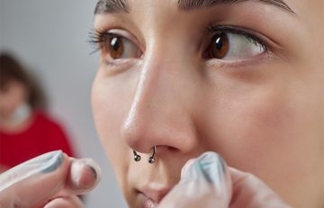 Woman getting a septum piercing