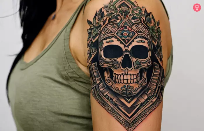 Woman with a neo-traditional Aztec skull tattoo on forearm