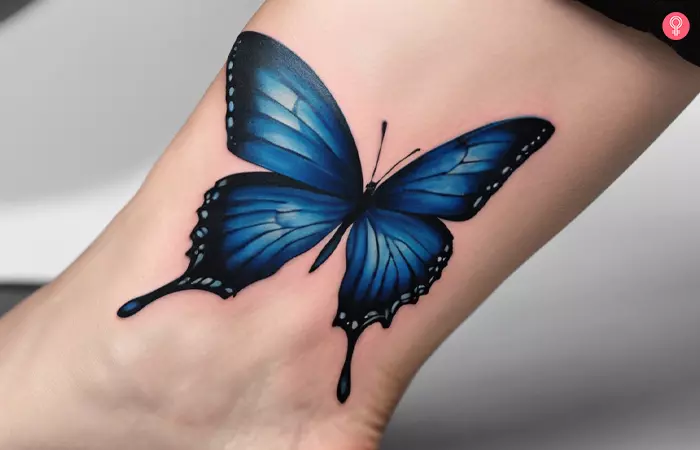 Blue morpho butterfly tattoo on a woman’s ankle