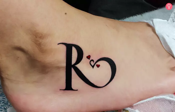 R tattoo with mini hearts on the ankle