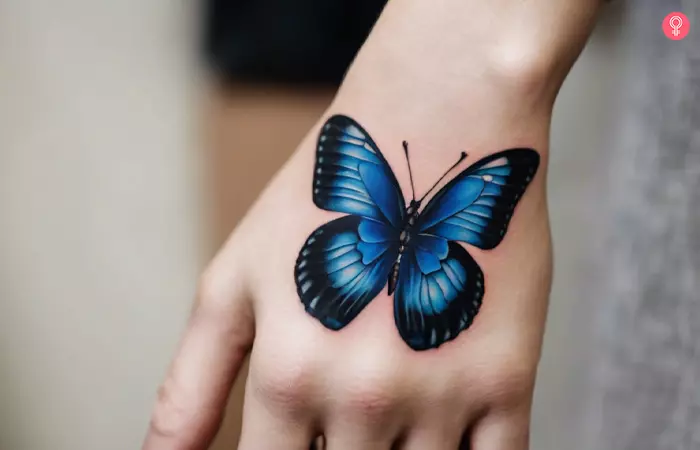 Blue butterfly tattoo on a woman’s hand