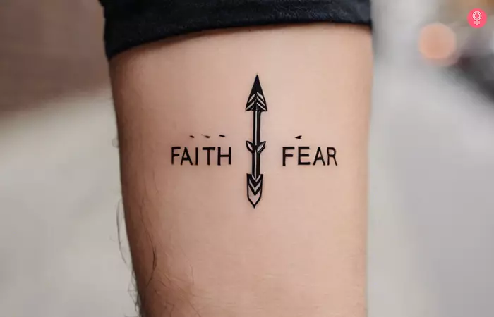 A faith over fear tattoo with an arrow