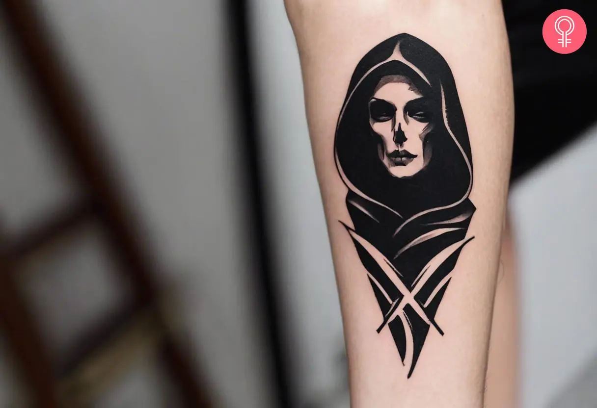 A Grim Reaper face tattoo on the forearm of a woman