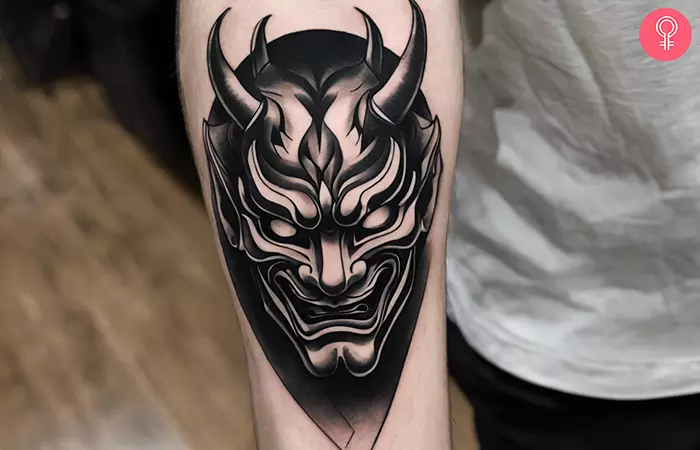 A black and gray hannya mask tattoo