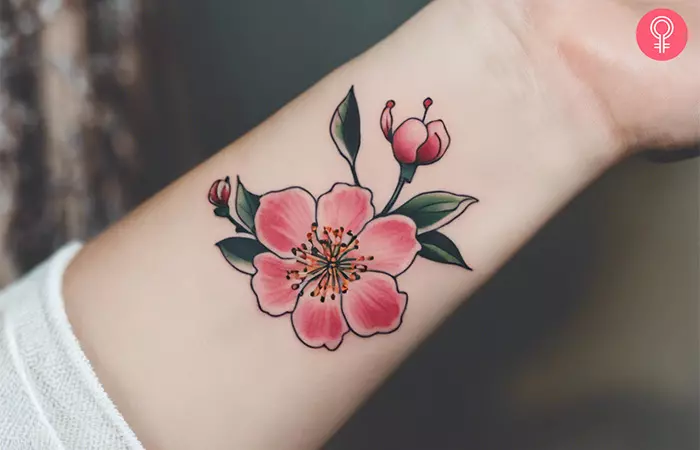 A cherry blossom flower tattoo on the wrist
