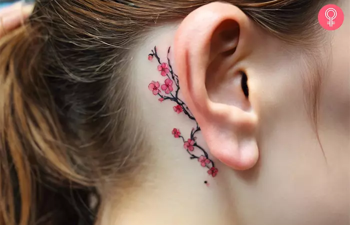 A cherry blossom vine tattoo behind the ear