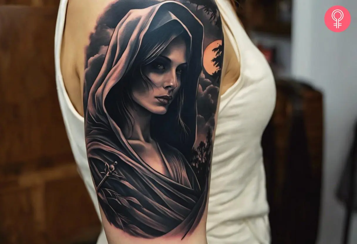 A female Grim Reaper tattoo on the upper arm of a woman