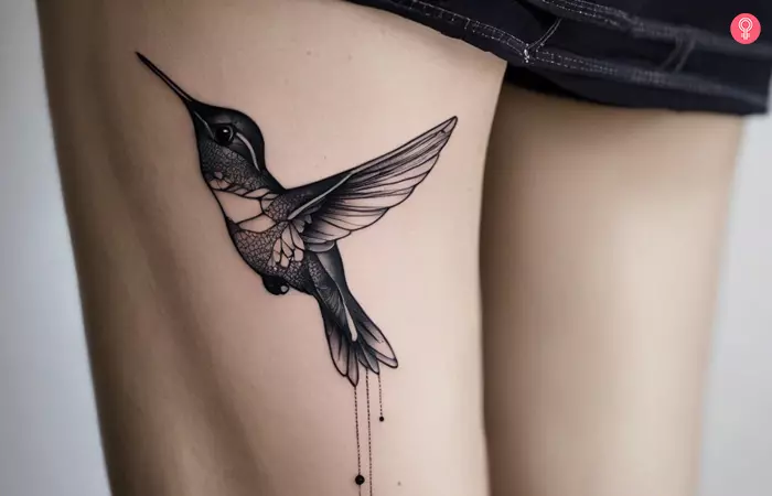 A fine line hummingbird tattoo on the leg