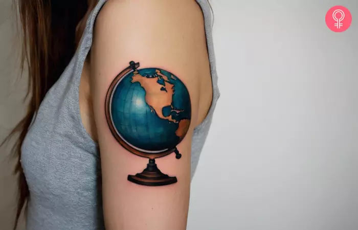 A globe tattoo on the arm of a woman