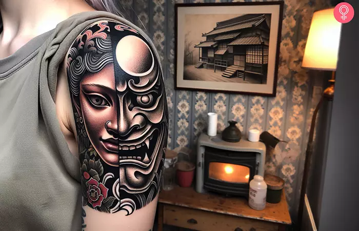 A half hannya mask tattoo on a woman’s upper arm