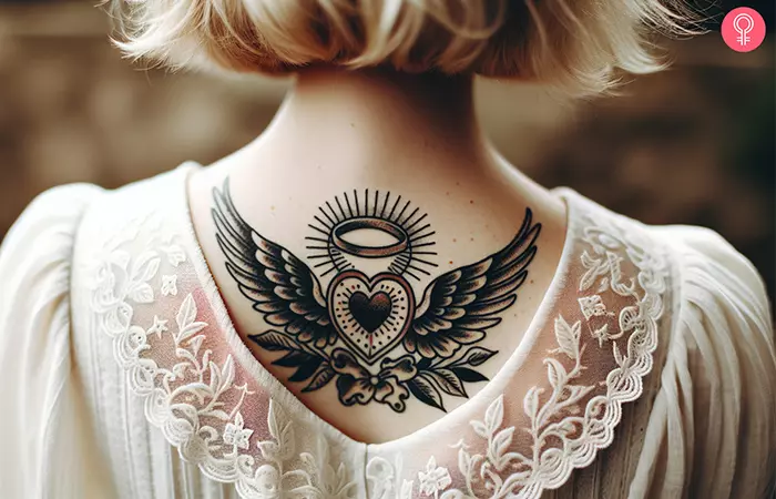 A heart tattoo with wings and a halo on a woman’s back