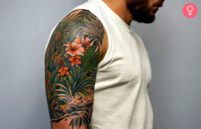 A man sporting a sleeve tattoo of a jungle.