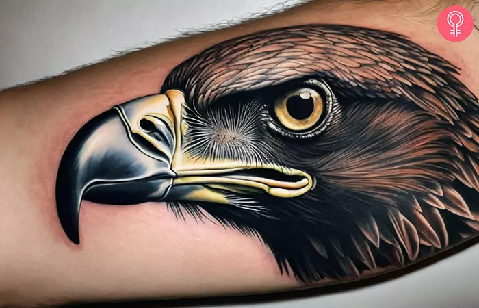 A man wearing a realistic vulture tattoo on the forearm