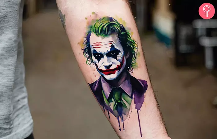 A man with a Joker face tattoo on the inner arm