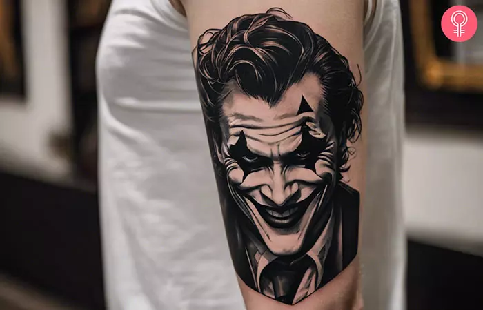 A man with a Joker smile tattoo on his upper arm