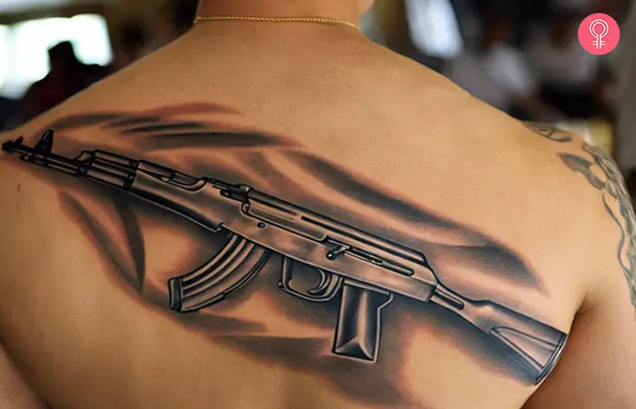 A man with a gangster AK-47 tattoo on his back