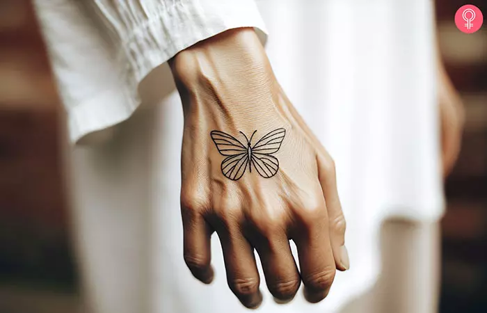 A man with a stick and poke butterfly tattoo on the back of his hand