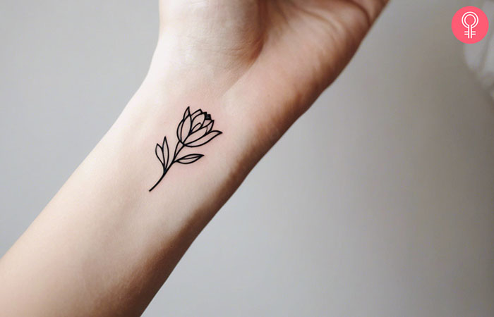 A minimalist tulip tattoo on the wrist