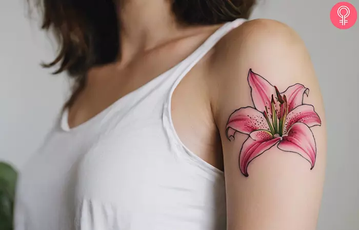 A pink stargazer lily tattoo on the upper arm