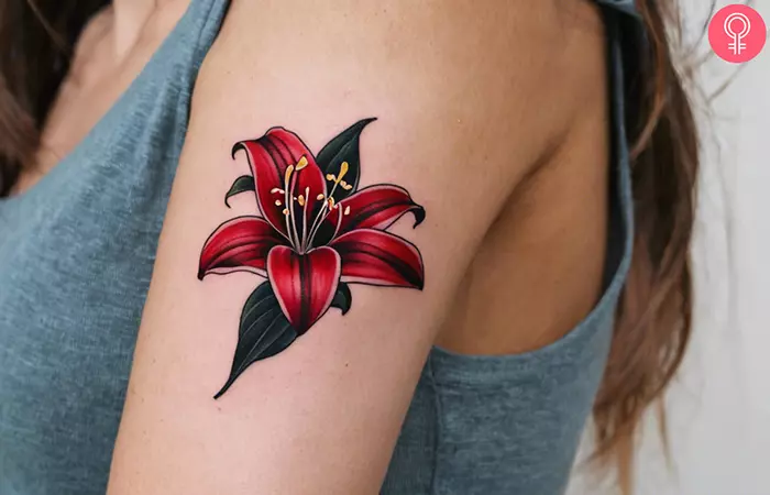 A red and black stargazer lily tattoo on the upper arm
