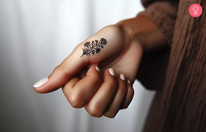 A small floral tattoo on a woman’s thumb